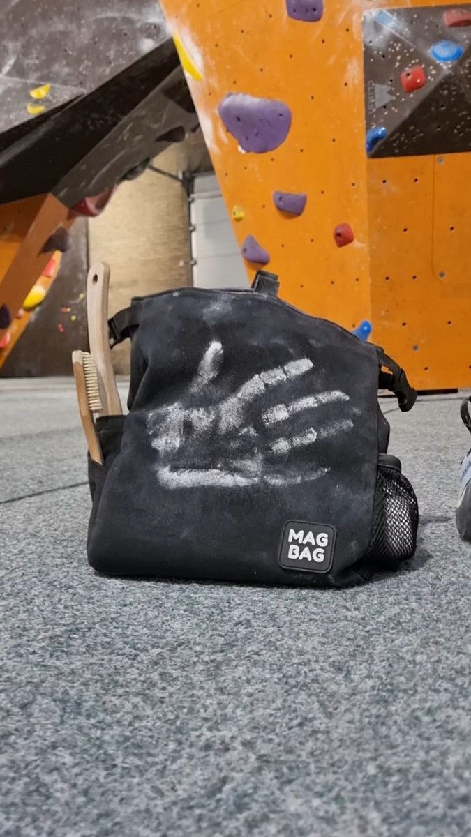 A drawn-on MAG BAG chalk bag in the bouldering gym
